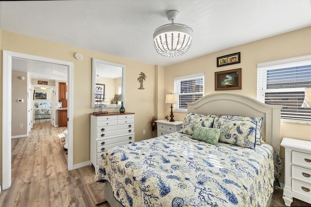 bedroom featuring a notable chandelier and light hardwood / wood-style floors