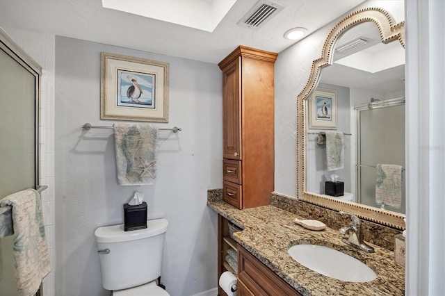 bathroom featuring a shower with door, vanity, and toilet