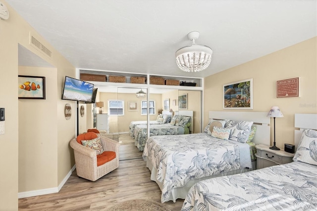 bedroom featuring light hardwood / wood-style flooring, a closet, and a notable chandelier