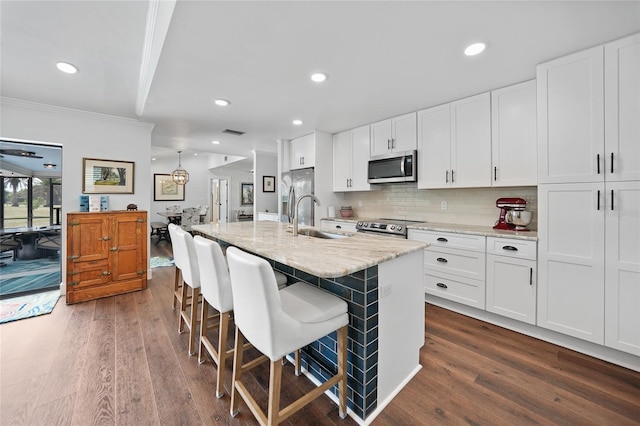 kitchen featuring white cabinetry, a center island with sink, stainless steel appliances, and dark hardwood / wood-style floors