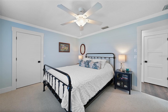 carpeted bedroom featuring ceiling fan and crown molding