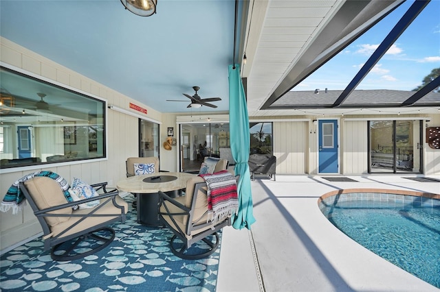 view of pool featuring glass enclosure, ceiling fan, and a patio area