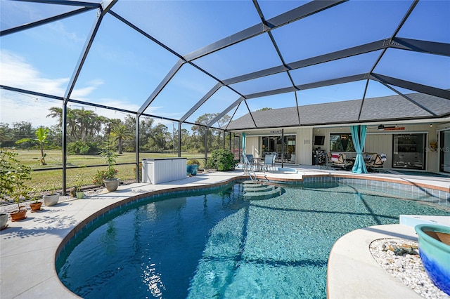 view of swimming pool with ceiling fan, a lanai, and a patio