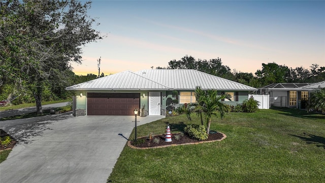 ranch-style home with a garage and a lawn