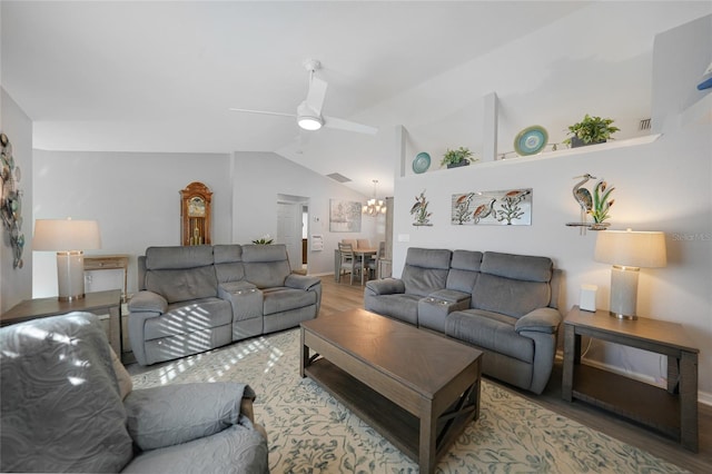 living room with hardwood / wood-style floors, ceiling fan with notable chandelier, and vaulted ceiling