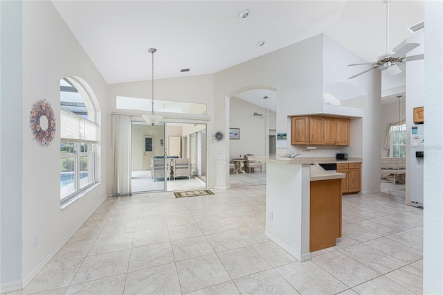 kitchen featuring kitchen peninsula, ceiling fan, white refrigerator with ice dispenser, light tile patterned floors, and high vaulted ceiling