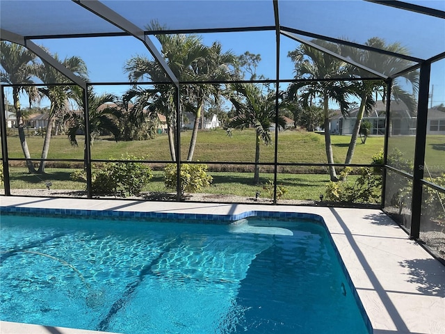 view of swimming pool with glass enclosure and a lawn