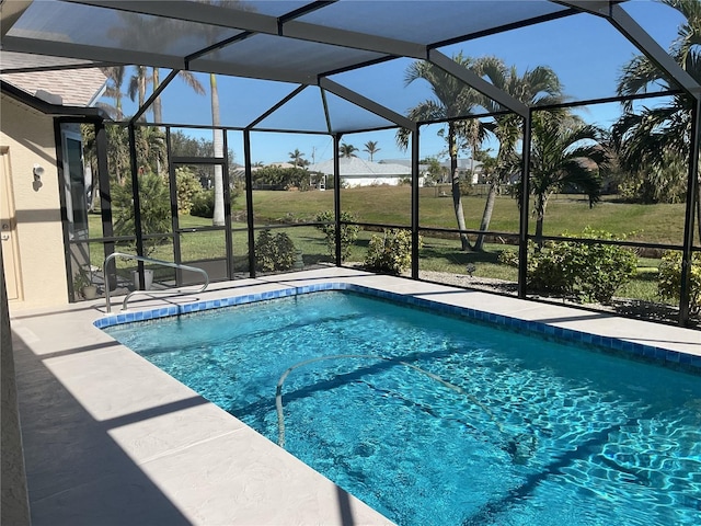 view of swimming pool featuring a lawn and glass enclosure