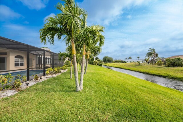 view of yard with a water view and glass enclosure