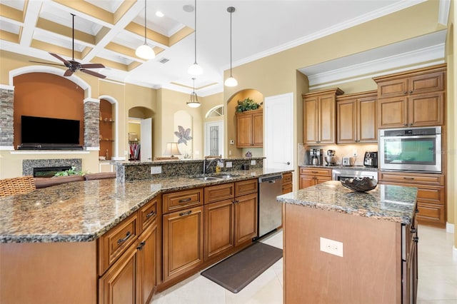 kitchen with a large island, hanging light fixtures, coffered ceiling, dark stone countertops, and appliances with stainless steel finishes