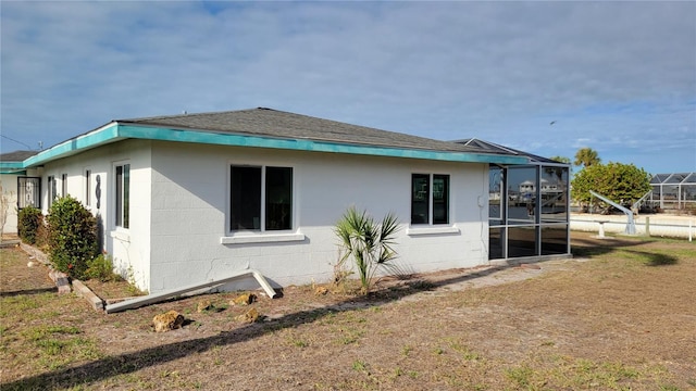 view of side of home with a lanai and a yard