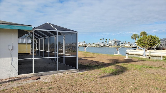 view of yard with a water view and glass enclosure