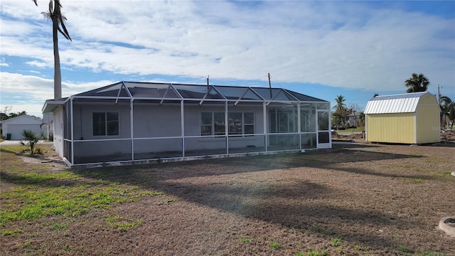 rear view of property with a storage unit and glass enclosure