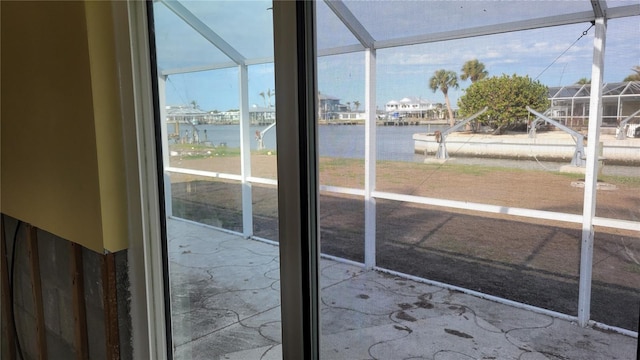 unfurnished sunroom featuring a water view