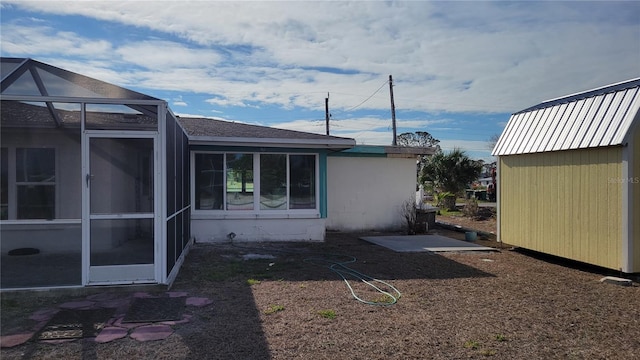 view of side of home with a shed and a lanai