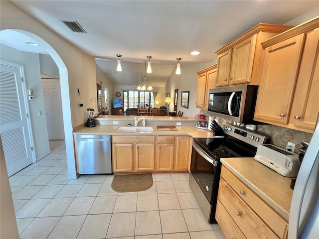 kitchen with kitchen peninsula, light tile patterned floors, stainless steel appliances, and sink