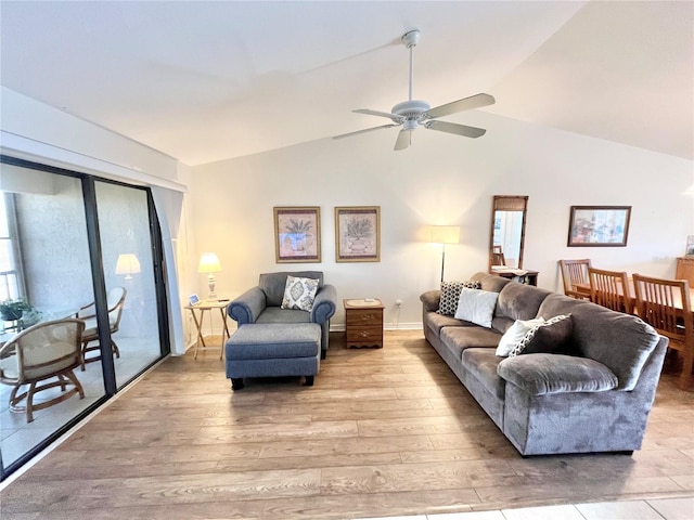 living room featuring ceiling fan, light hardwood / wood-style floors, and vaulted ceiling