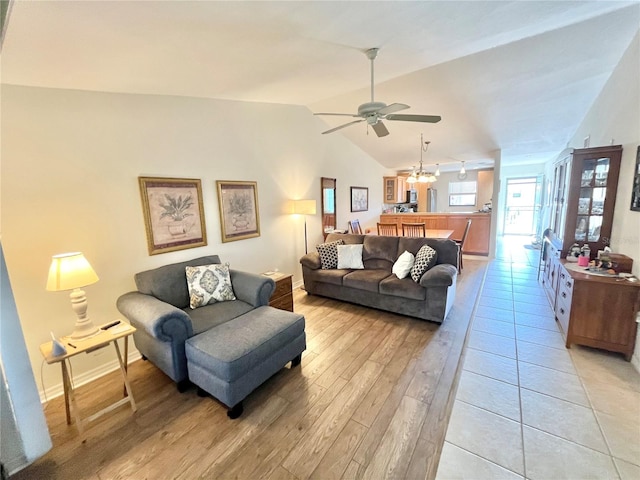 living room with ceiling fan, lofted ceiling, and light wood-type flooring