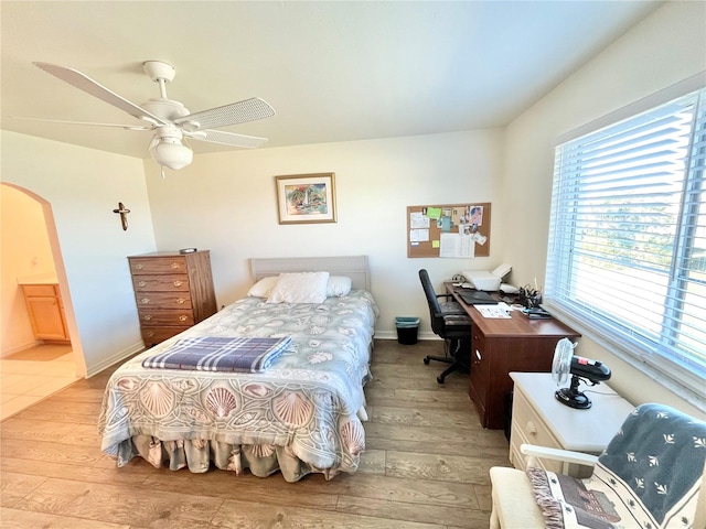 bedroom with ceiling fan, light hardwood / wood-style floors, and connected bathroom