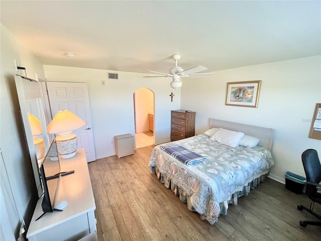 bedroom with light hardwood / wood-style floors, ensuite bath, and ceiling fan