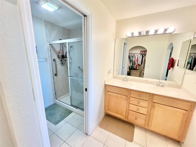 bathroom with tile patterned floors, vanity, and a shower with door