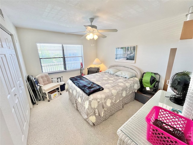 carpeted bedroom with ceiling fan and a closet