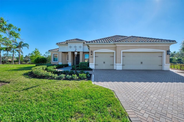 mediterranean / spanish home featuring a garage and a front yard