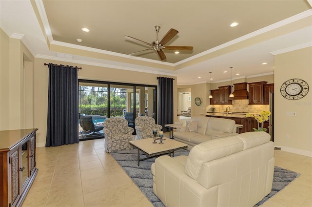 living room featuring a raised ceiling, crown molding, ceiling fan, and light tile patterned floors