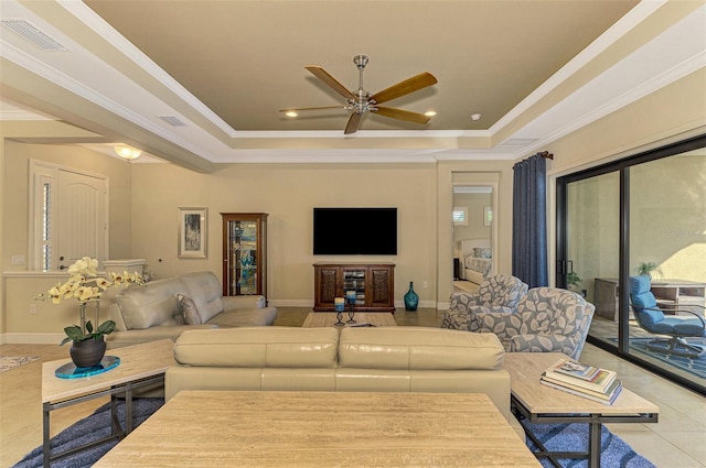 tiled living room featuring a tray ceiling, ceiling fan, and crown molding