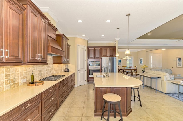 kitchen featuring premium range hood, sink, an island with sink, a kitchen bar, and stainless steel appliances