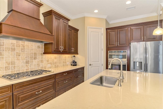 kitchen featuring backsplash, premium range hood, ornamental molding, stainless steel appliances, and decorative light fixtures