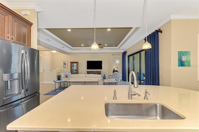 kitchen featuring stainless steel refrigerator with ice dispenser, decorative light fixtures, ornamental molding, and sink