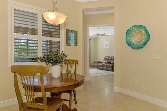 dining space with ceiling fan, crown molding, and light tile patterned flooring