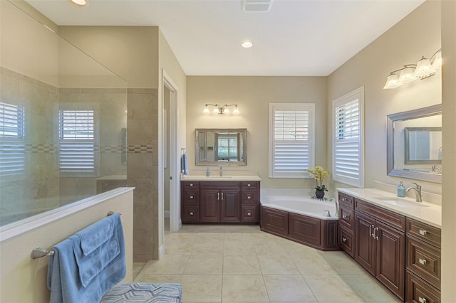 bathroom with tile patterned flooring, vanity, and separate shower and tub