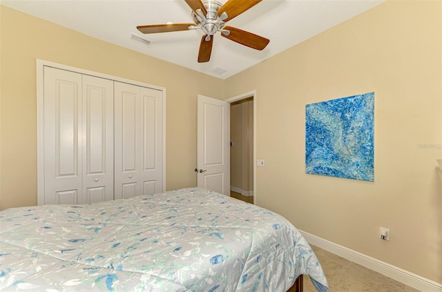 tiled bedroom featuring ceiling fan and a closet