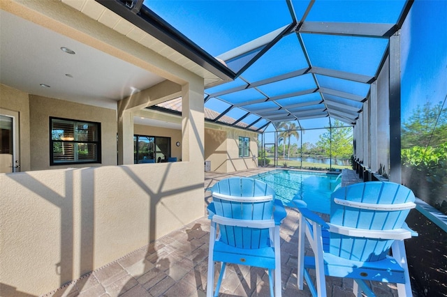 view of pool with glass enclosure and a patio