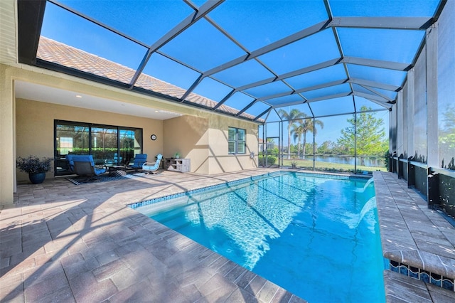 view of pool with glass enclosure, pool water feature, and a patio area