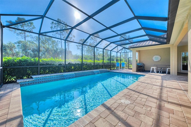 view of swimming pool featuring glass enclosure and a patio area