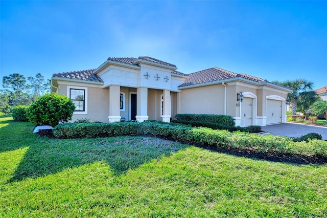 mediterranean / spanish home with a front yard and a garage