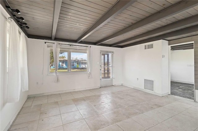 tiled empty room with beamed ceiling, a wealth of natural light, and wooden ceiling