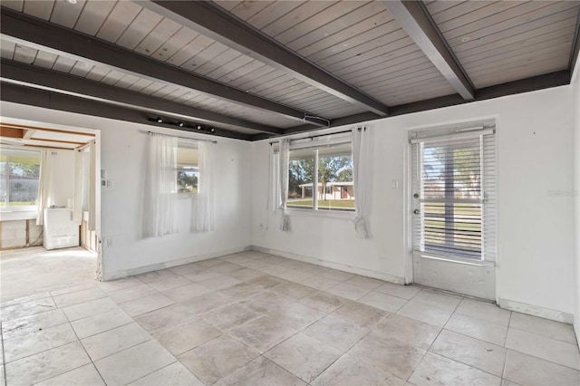 unfurnished room with a healthy amount of sunlight, wooden ceiling, and beam ceiling