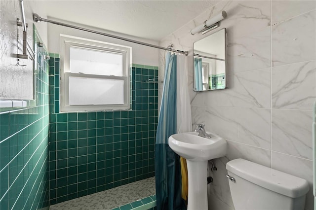 bathroom featuring a shower with curtain, toilet, and tile walls