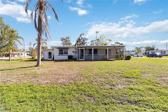 view of front of home featuring a front yard and a sunroom