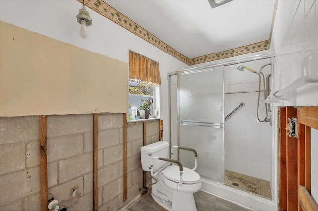 bathroom featuring toilet and a shower with shower door