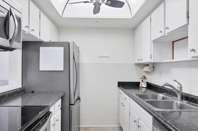 kitchen featuring appliances with stainless steel finishes, white cabinetry, ceiling fan, and sink