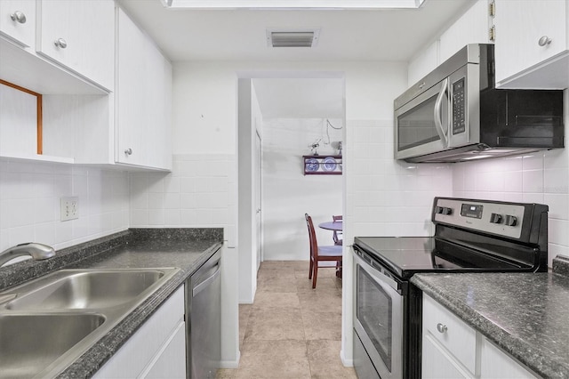 kitchen featuring white cabinetry, sink, light tile patterned floors, and stainless steel appliances