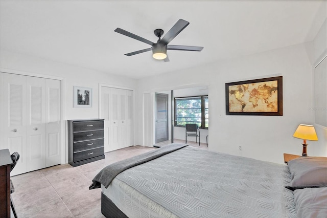 tiled bedroom featuring ceiling fan and multiple closets