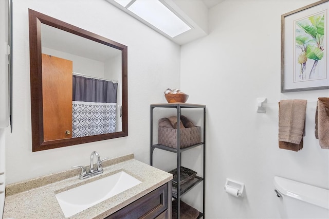 bathroom with vanity, toilet, and curtained shower