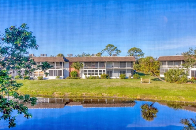 rear view of house featuring a lawn and a water view