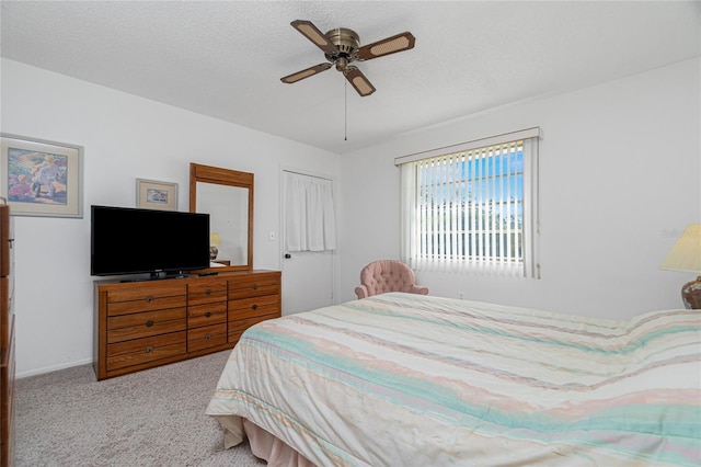 carpeted bedroom featuring ceiling fan, a textured ceiling, and a closet